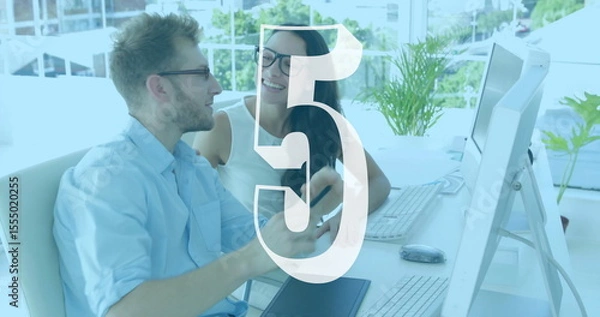 Fototapeta Two colleagues discussing work at desk with number five image overlay