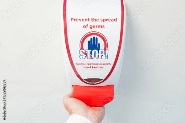 Fototapeta Hospital medic seen using a typical antibacterial foam had dispenser within an NHS hospital. Used before entry to a surgical ward.