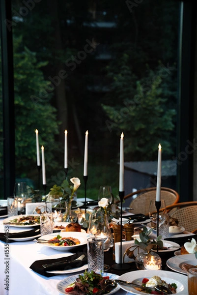 Obraz Elegant Dinner Table Set with Candle Holders, Fine Dishes, and Greenery for a Sophisticated Dining Experience