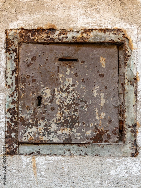 Obraz Old rusty alms box on wall with peeling plaster, copy space