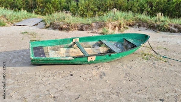 Fototapeta Small old green wooden pleasure boat on yellow sand in the Dunes in spring