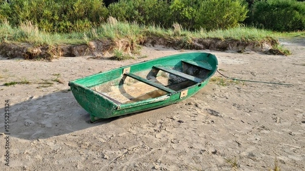 Fototapeta Small old green wooden pleasure boat on yellow sand in the Dunes in spring