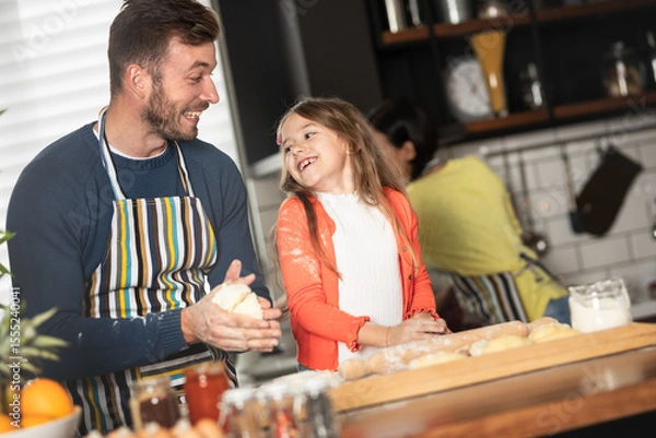 Obraz Happy father and girl having fun while making a cake in the kitchen.