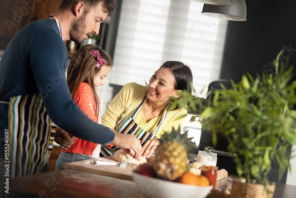 Obraz Parents in kitchen baking with their little girl learn through play most important life skills and values is in childhood.