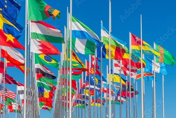 Fototapeta Lots of world's countries national flags waving on the wind, with Tajik, Bahrain, Nigerian Moldavian banners in the foreground, Doha, Qatar