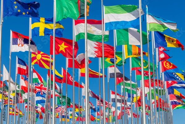 Fototapeta Lots of world's countries national flags waving on the wind, with Sweden, Serbian, Macedonian, Tajik, Bahrain, Nigerian Moldavian banners in the foreground, Doha, Qatar
