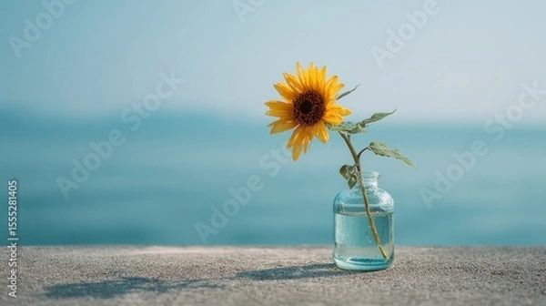 Obraz Minimalist Sunflower in Glass Vase by the Sea Under Soft Morning Light