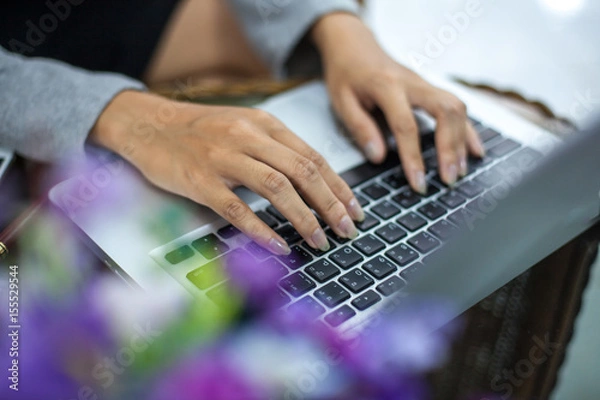 Fototapeta woman's hands using laptop with blank screen on table in offie
