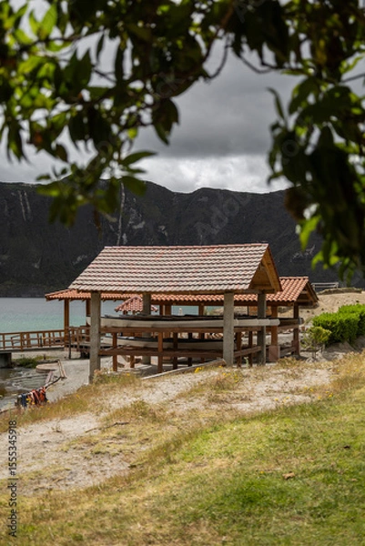 Fototapeta A charming wooden pier on the lake shore serves as a gateway for tourists boarding boats. Surrounded by peaceful water and nature, it offers a perfect start to lake tours.

