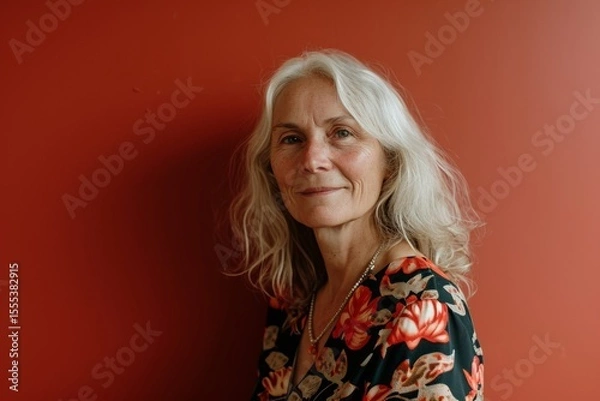 Fototapeta Portrait of a senior woman on a red background. The concept of pensioners and lifestyle.