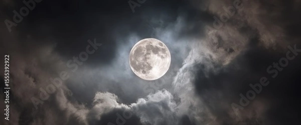Fototapeta Dramatic Full Moon Shining Through Dark Clouds in Night Sky with Celestial Glow
