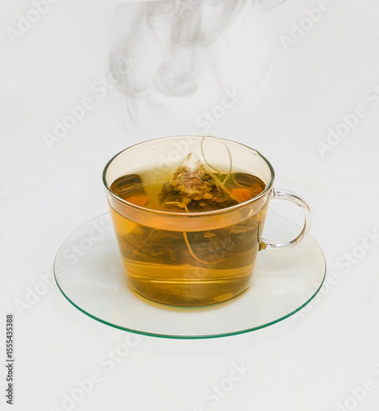 Obraz Hot herbal camomile tea in glass teacup with steam floating above