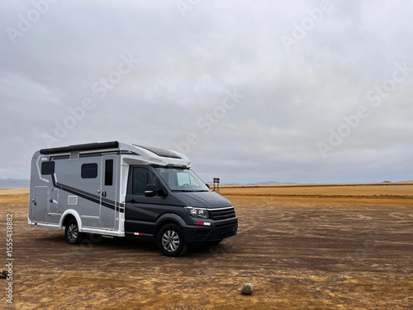 Fototapeta Modern RV motorhome while standing desert landscape in National Park Reserve Paracas in Pisco Province, Peru. Caravan exploring red sand beaches, and wildlife of national park. 
