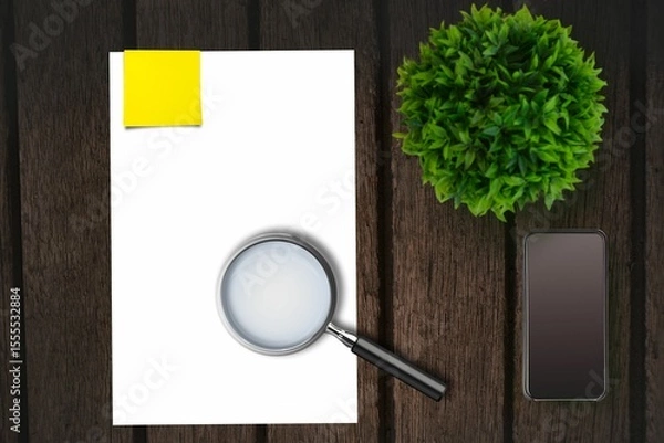Obraz Magnifying glass on paper on the side of smartphone