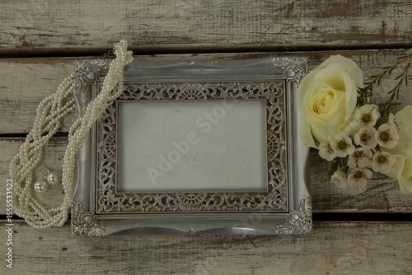Obraz Photo frame, necklace and flowers on wooden table