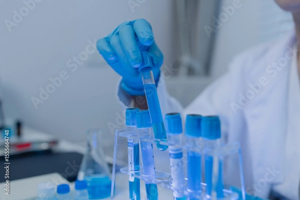 Fototapeta a female chemist is testing various liquid compounds in a lab, a scientist is doing research on the development of science in a lab, laboratory, test tube, scientific
