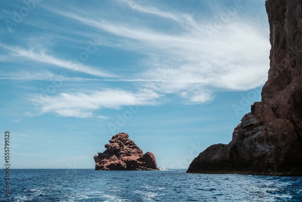 Fototapeta A tourist boat passes between the jagged rocks of the Scandola Nature Reserve created in 1975 on the west coast of the Mediterranean island of Corsica