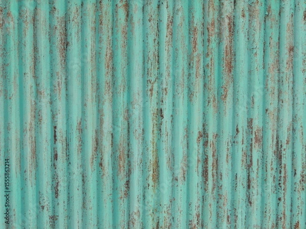 Fototapeta metal fence with traces of rust on peeling green painted surface, with relief ribbed texture, full frame, detailed texture of iron fence, vintage rough brown green background