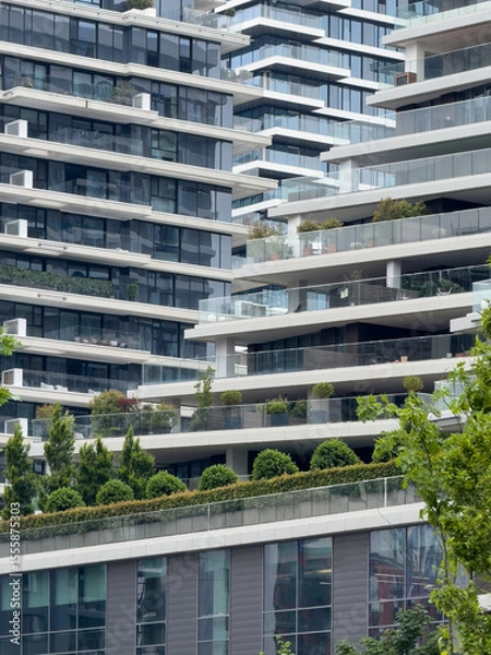 Fototapeta Modern architectural design featuring multiple residential buildings with greenery in urban setting
