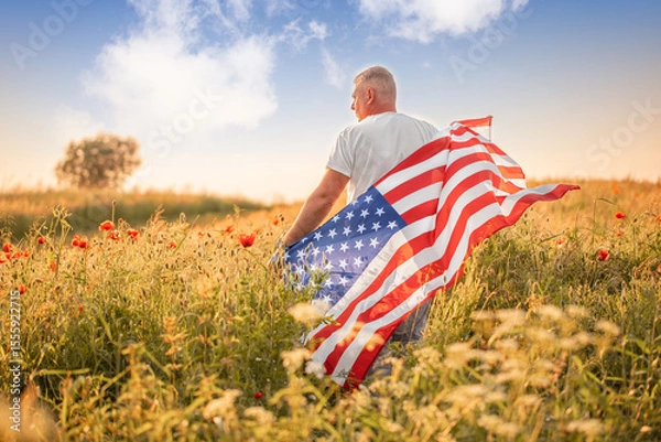 Obraz A proud man wrapped in the American flag stands in a golden field of wildflowers under a vibrant sky, symbolizing patriotism, freedom, and connection to the land