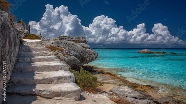 Fototapeta White Sand Steps Leading to a Turquoise Ocean Under a Bright Blue Sky with Fluffy Clouds