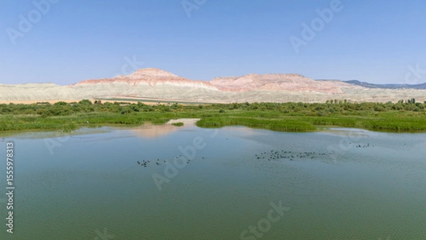 Fototapeta Nallihan Bird Sanctuary Beypazari Ankara Serene lake landscape with colorful mountains reflecting on the water. A tranquil view of a lake, mirroring the vibrant hues of the surrounding mountains.