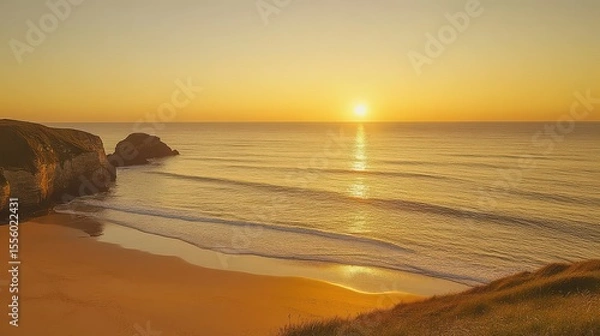 Fototapeta Golden hour at the beach with cliffs and waves reflecting the sun setting over the ocean horizon
