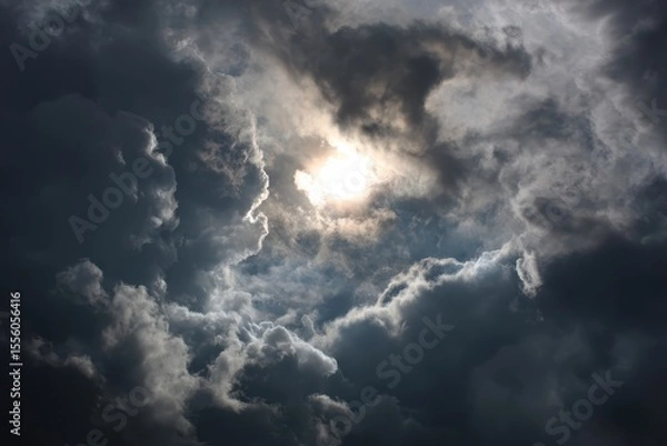 Fototapeta Sun glows through dark clouds in sky. Possible use dramatic or ominous backdrop