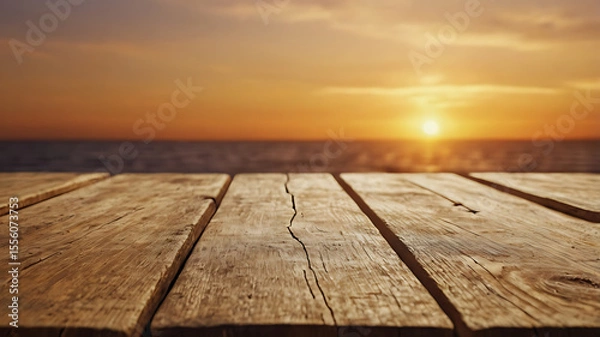 Fototapeta Golden sunset casting a warm, glowing light across the horizon with soft gradients of orange and gold in the sky. In the foreground, place a vintage wooden table or plank surface with a rustic 