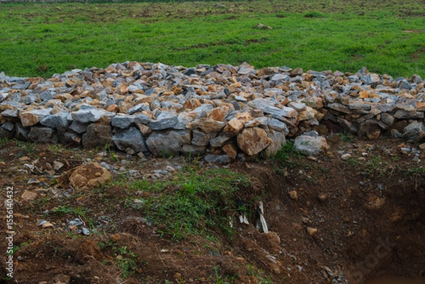 Obraz Pile of Rocks on Grass Next to a Dirt Excavation Site