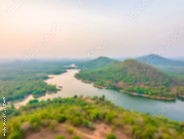 Fototapeta Blurred lake surrounded by green mountains