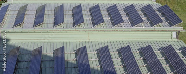 Obraz Solar panels installed on a green-roofed building in the Italian Alps. A modern approach to sustainability and clean energy in a scenic mountain environment.