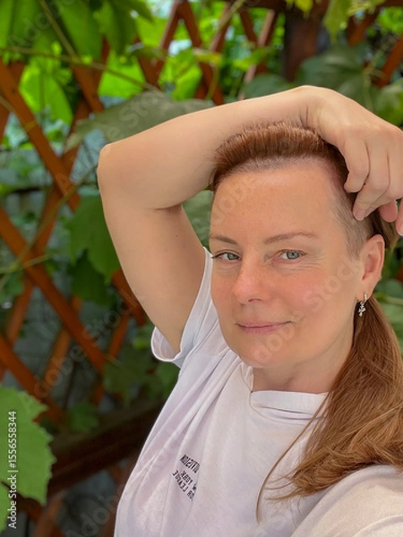 Fototapeta portrait of a mature woman in a summer gazebo with a vine background
