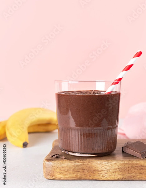 Fototapeta Chocolate banana smoothie on pink background. Copy space.