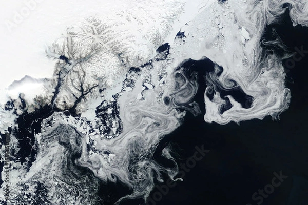 Fototapeta Swirls of sea ice off the coast of Greenland seen in a satellite image from space. Image courtesy of NASA.