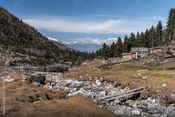 Obraz Rustic mountain village with wooden cabins and alpine landscape