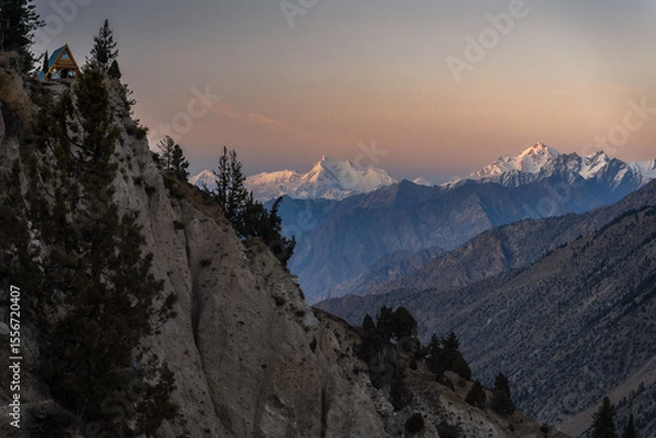 Obraz Sunset View of Remote Cabin on Mountain Ridge Overlooking Snowy Peaks