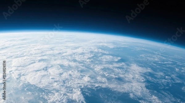 Obraz View of Earth's curvature from space, showing the thin blue atmosphere and vast cloud formations over the planet's surface.