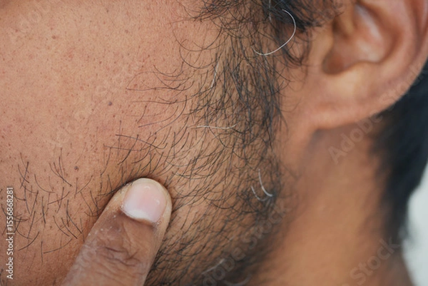 Fototapeta Close-up view of a man touching his facial hair