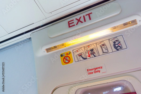 Fototapeta Exit sign and symbols in an aircraft cabin