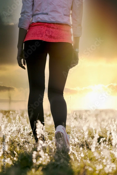 Fototapeta Walking and enjoying the sunset in the meadow, walking in nature is a care for maintaining health, the concept of a healthy lifestyle