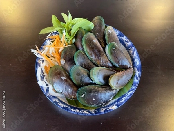Fototapeta Steamed mussels with basil leaves, selective focus