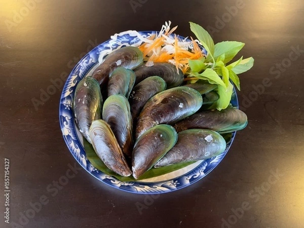 Fototapeta Steamed mussels with basil leaves, selective focus