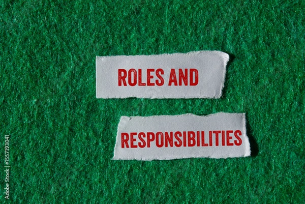 Obraz Roles and responsibilities message written on ripped torn paper pieces on green background. Conceptual roles and responsibilities symbol. Copy space.