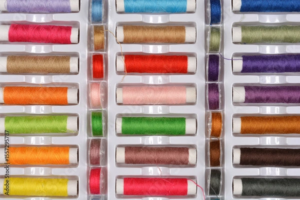 Obraz A top-down shot of a large assortment of colorful sewing threads neatly arranged in a white plastic storage box