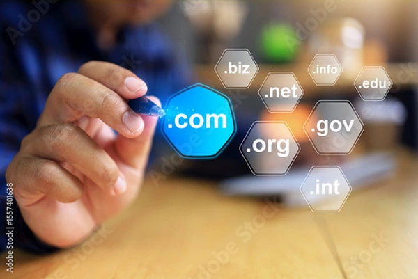 Fototapeta Domain name concept with businessman working on desktop to pointing a pen to selected .com to be a top level of domain in business website