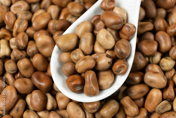 Fototapeta Dried vicia faba beans in a spoon close-up