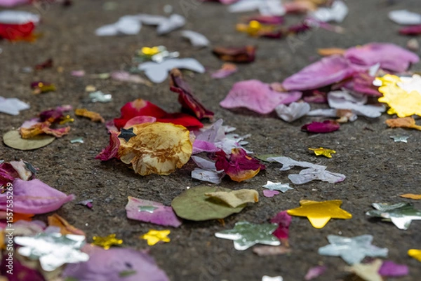 Fototapeta Colorful confetti and flower petals scattered on the ground after a joyful celebration in a vibrant community setting
