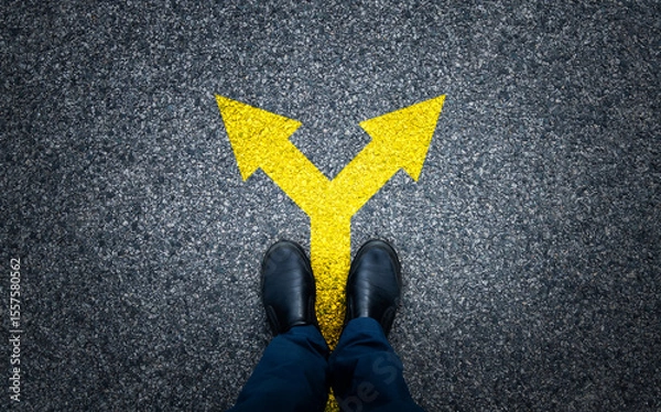 Obraz Man standing on asphalt road with arrow signs