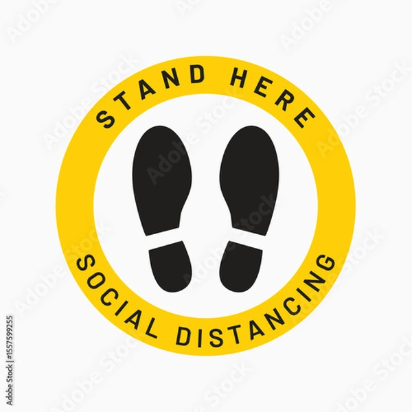 Fototapeta Social Distancing Reminder: A close-up view of a social distancing floor sticker. this visual element is a circular sign with bold text and footprint symbols.